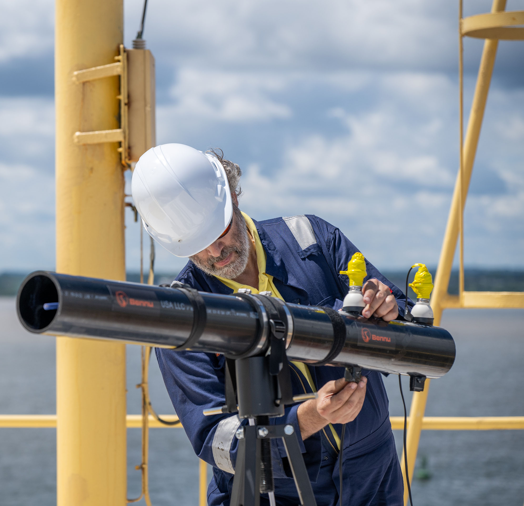 A man on a ship adjusting an instrument. 